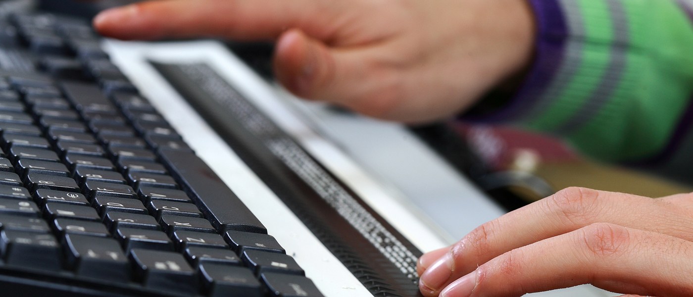 Manos sobre una línea braille